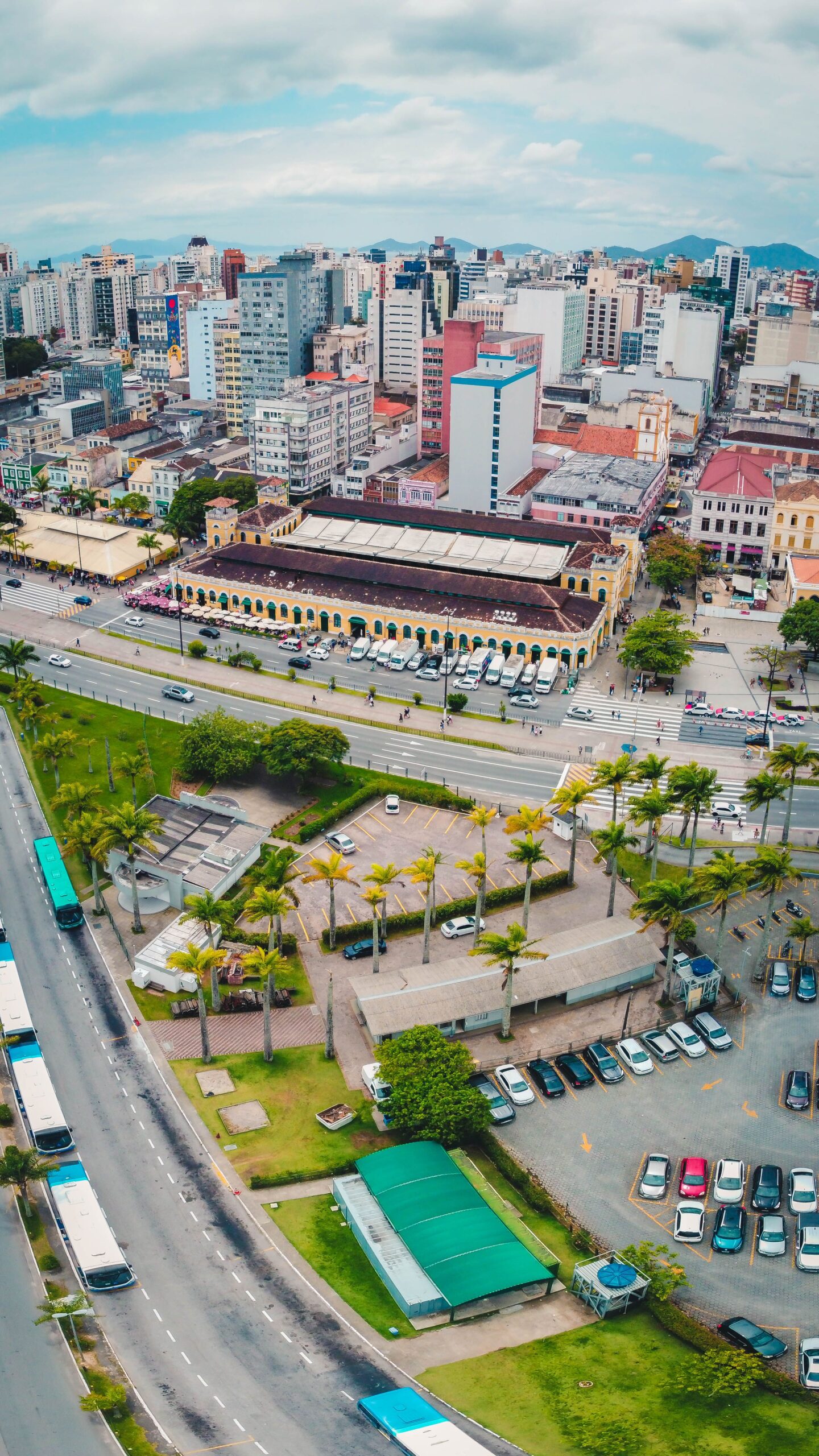 Home Aerial view of Florianópolis cityscape showcasing roads, buildings, and greenery.